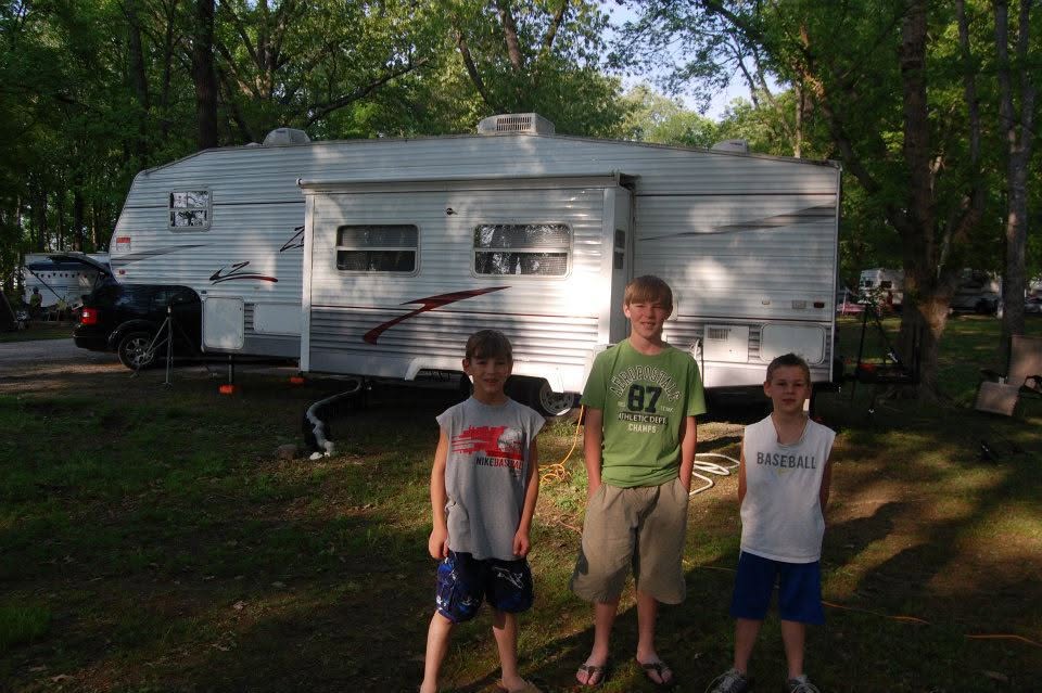 Three boys standing in front of the family's RV